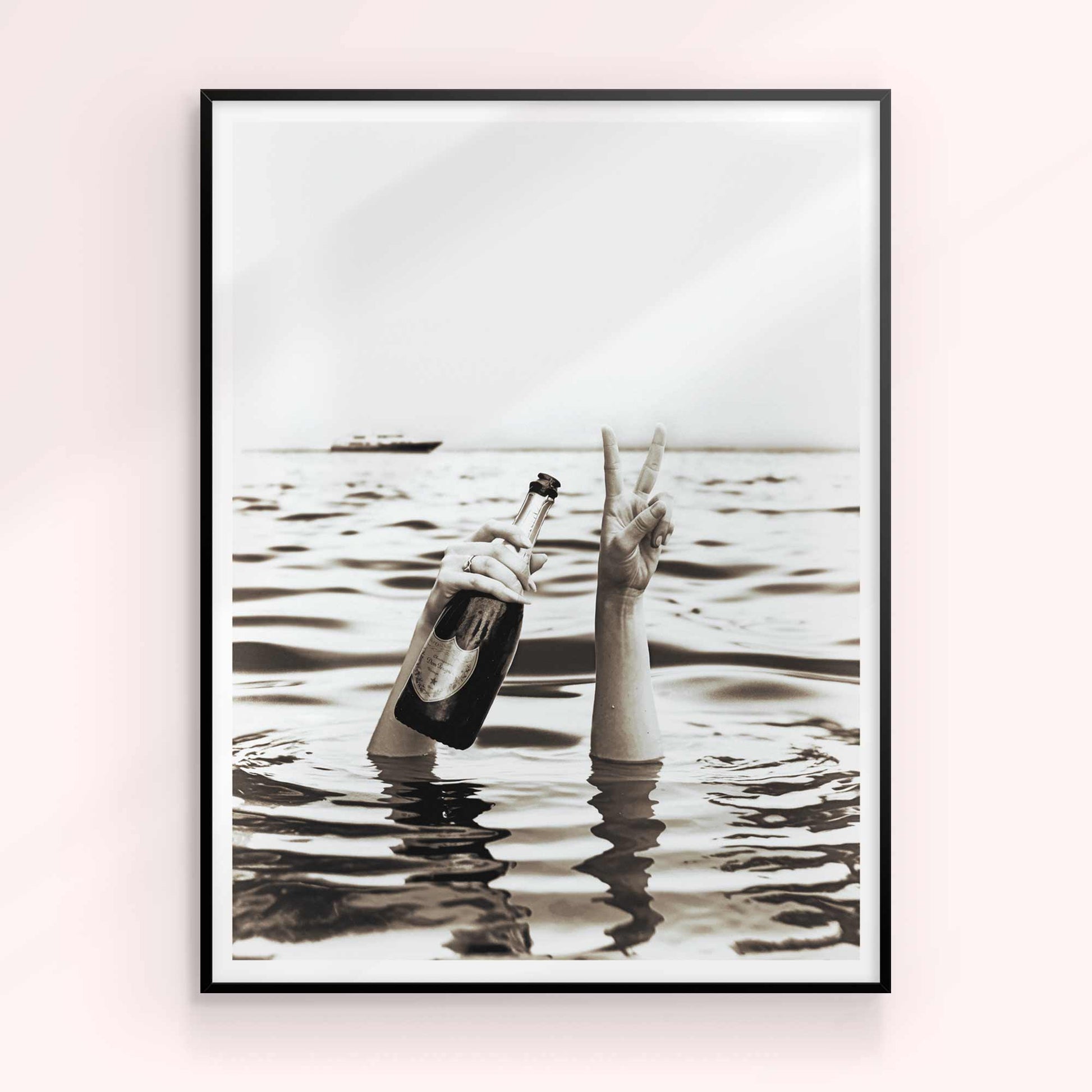 A woman's hands emerging from the sea, holding a bottle of champagne, with a yacht in the background.